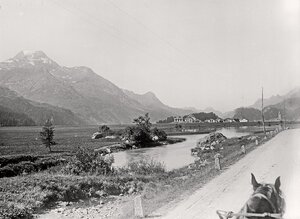 Blick von der Pferdekutsche über den Inn auf den Ort Sils-Baselgia am Silsersee. Am rechten Bildrand ist in der Ferne die Kirche des Ortes zu erkennen. Die Aufnahme entstand wohl während eines Ausflugs während des Familienurlaubs in Pontresina vom 20.August-14.September 1898.